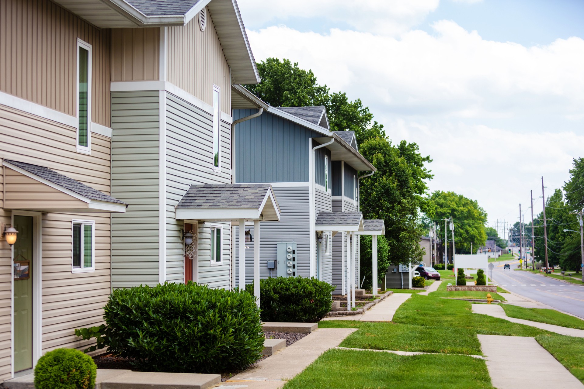 Groups of Townhouse Apartments with Healthy Green Yards on a Sunny Summer Day